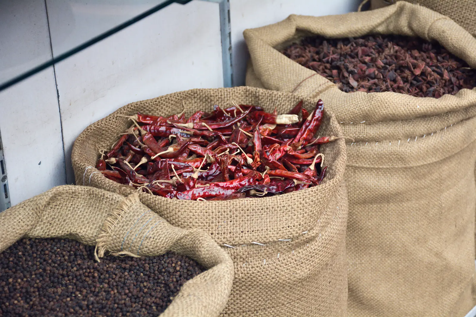 Hessian sacks of dried red chillies, star anise and black peppercorns at a spice trader