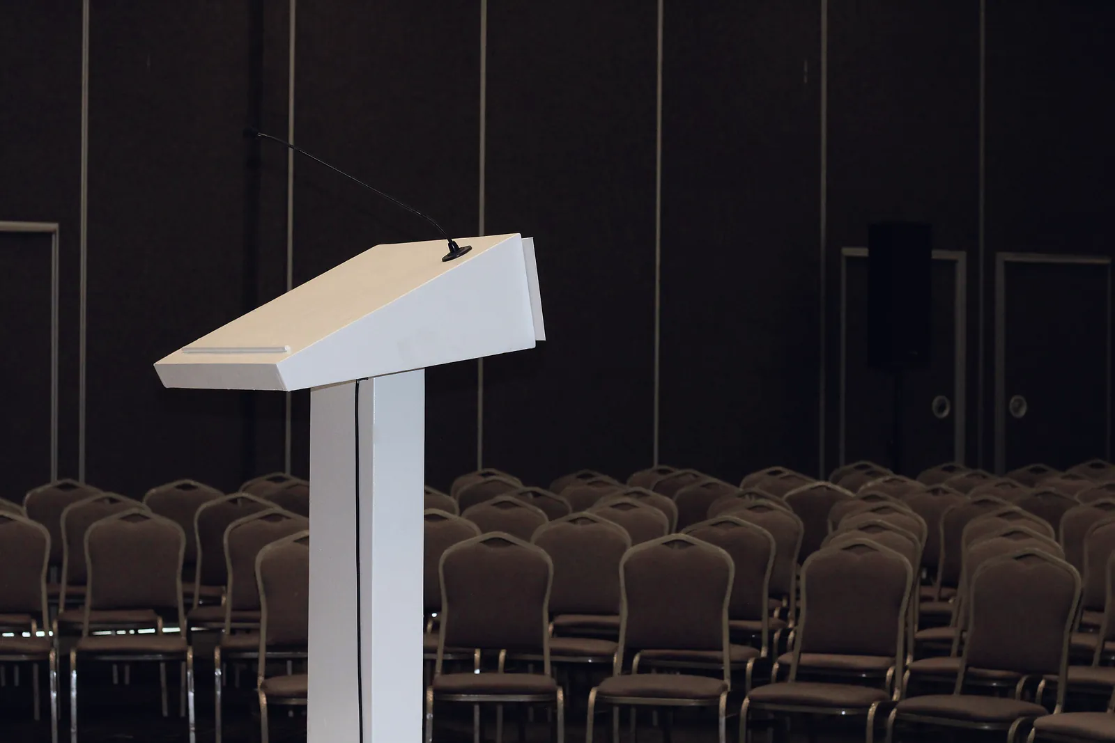 Conference hall set up for an event with a lectern and rows of seating