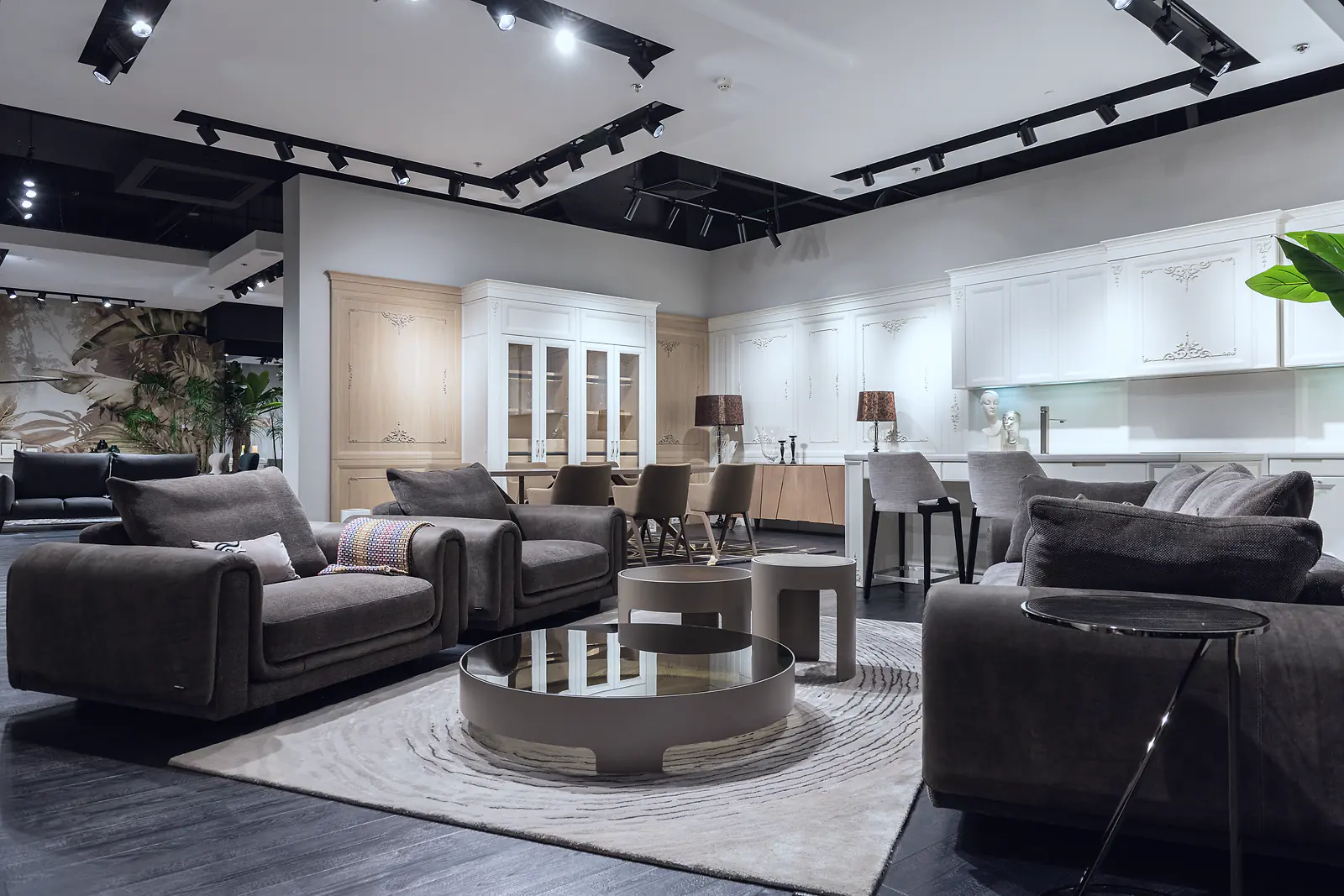 Grey sofas, armchairs and round coffee tables arranged in a furniture showroom