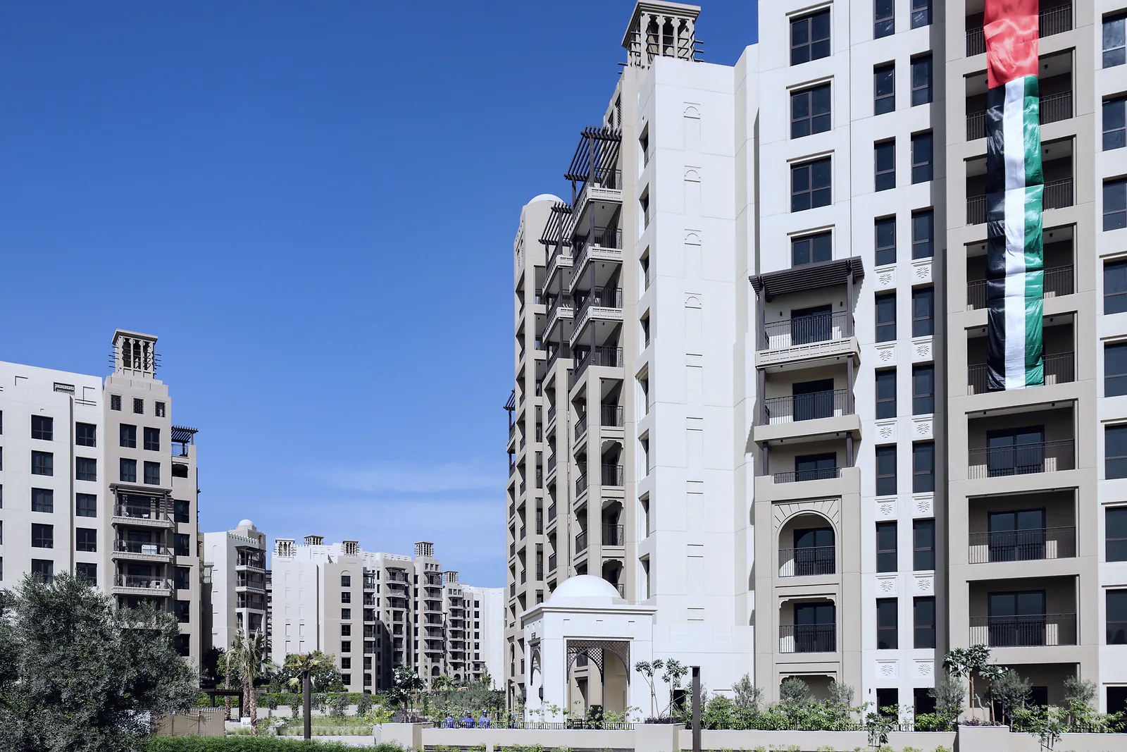 New residential buildings with wind-tower details under a clear sky in Dubai