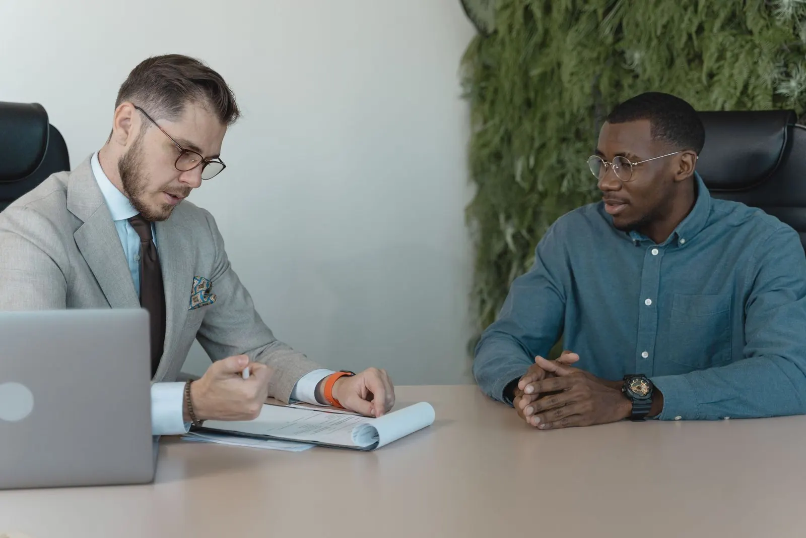 Recruiter interviewing a candidate across a desk in a bright office