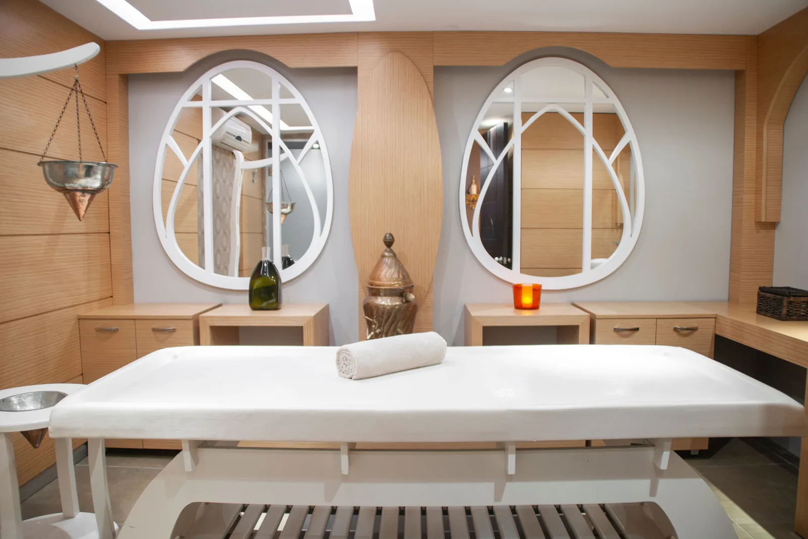 Massage table and rolled towel in a wood-panelled spa treatment room