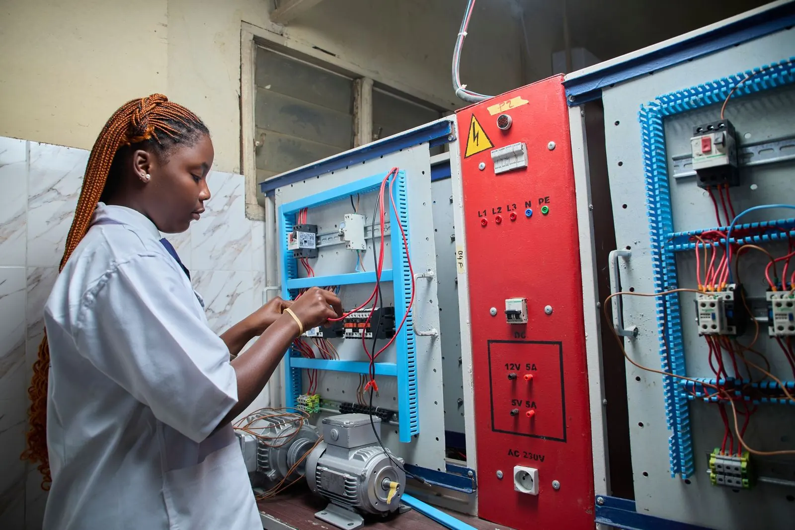 Technician wiring an electrical control panel for a technical services company