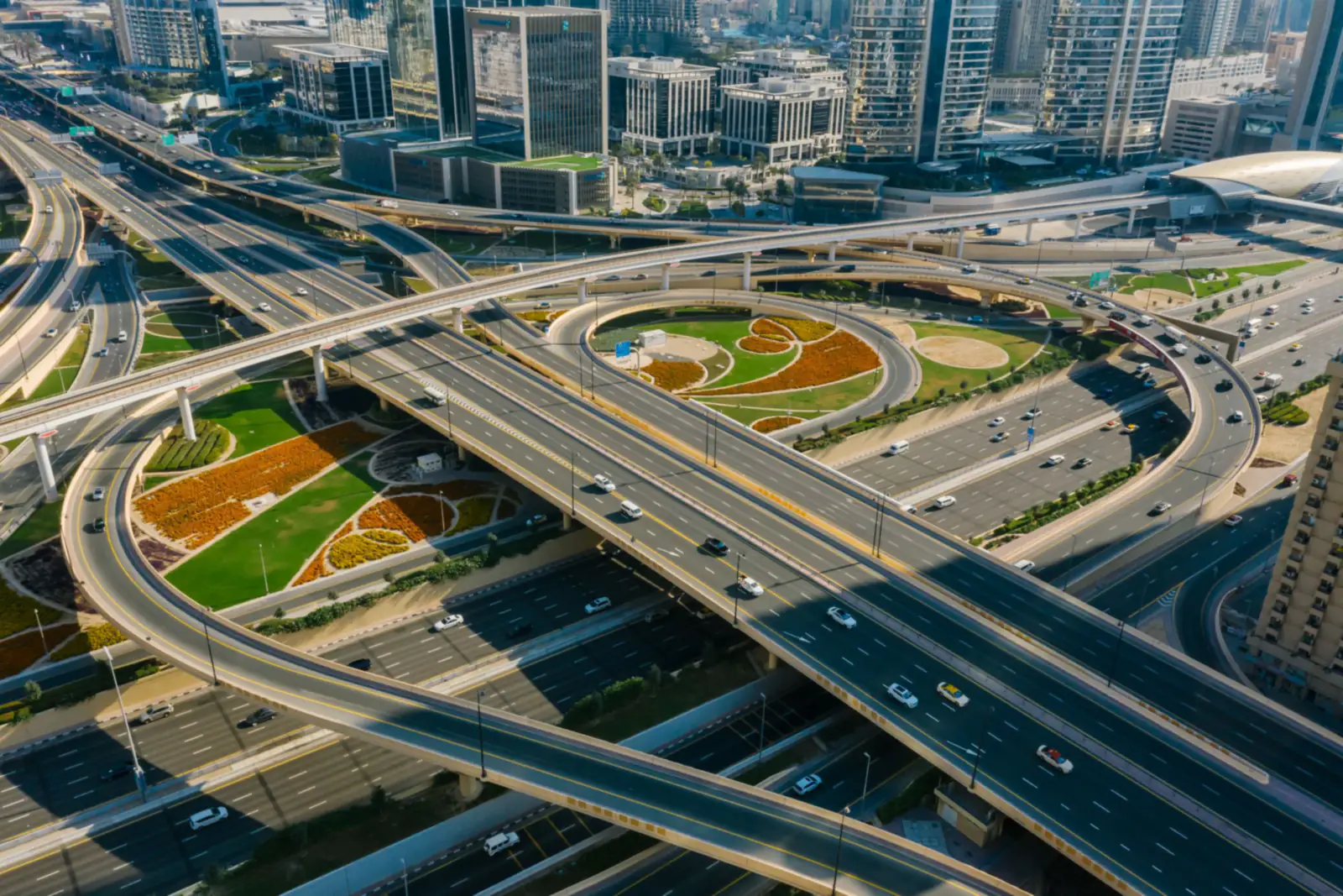 Aerial view of a multi-level Sheikh Zayed Road interchange in Dubai with landscaped gardens